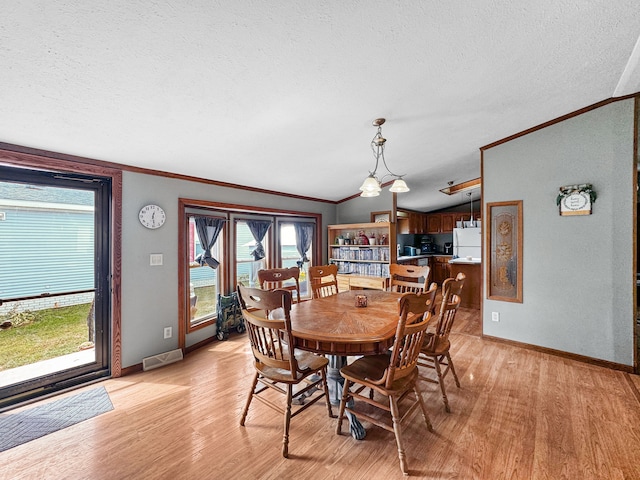 dining room with lofted ceiling, a notable chandelier, crown molding, a textured ceiling, and light hardwood / wood-style flooring