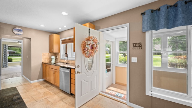 kitchen featuring recessed lighting, a sink, baseboards, decorative backsplash, and dishwasher