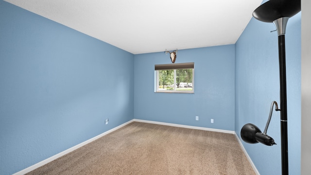 carpeted spare room featuring baseboards