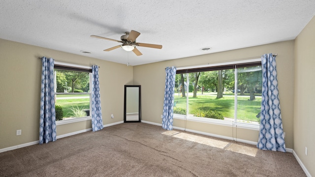 carpeted spare room featuring a ceiling fan, baseboards, visible vents, and a textured ceiling