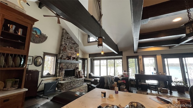 11720 Easy St, Kewadin, MI 49648 - living area with beam ceiling, a stone fireplace, plenty of natural light, and a towering ceiling
