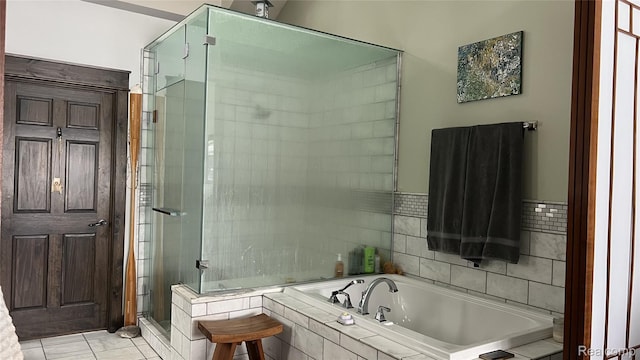 11720 Easy St, Kewadin, MI 49648 - bathroom featuring a bath, a shower stall, and tile walls