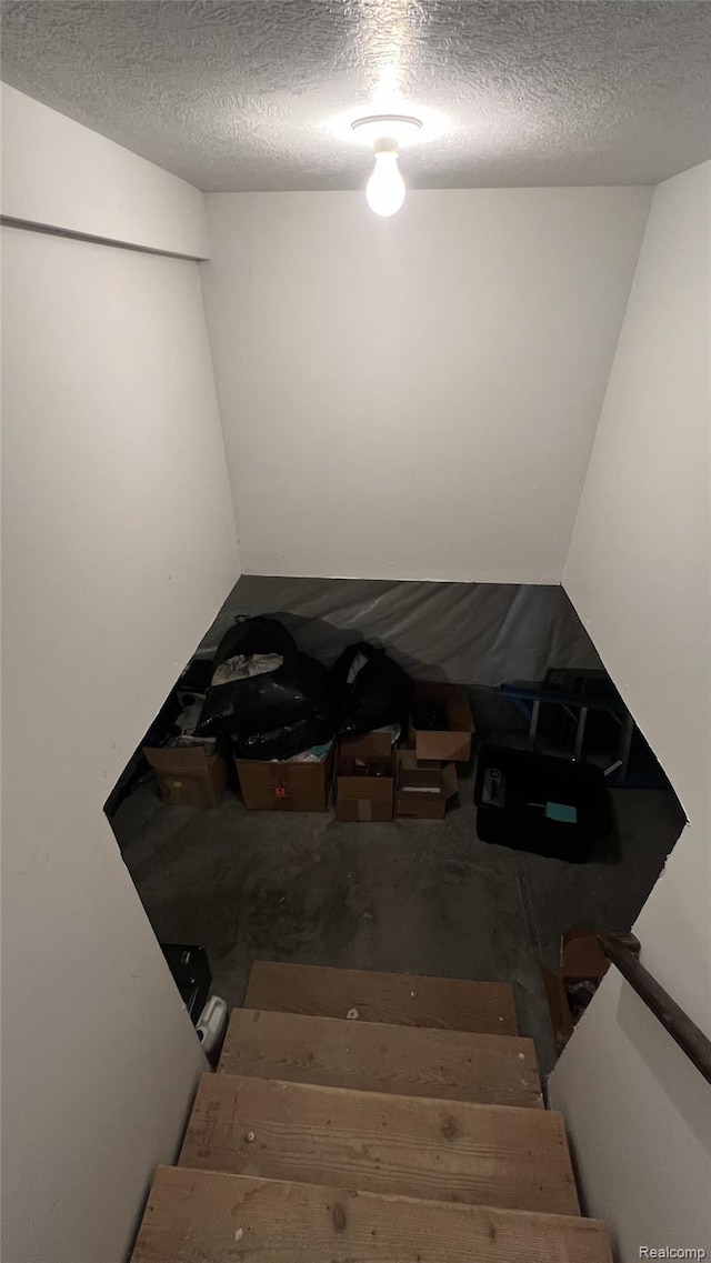 11720 Easy St, Kewadin, MI 49648 - stairway featuring a textured ceiling