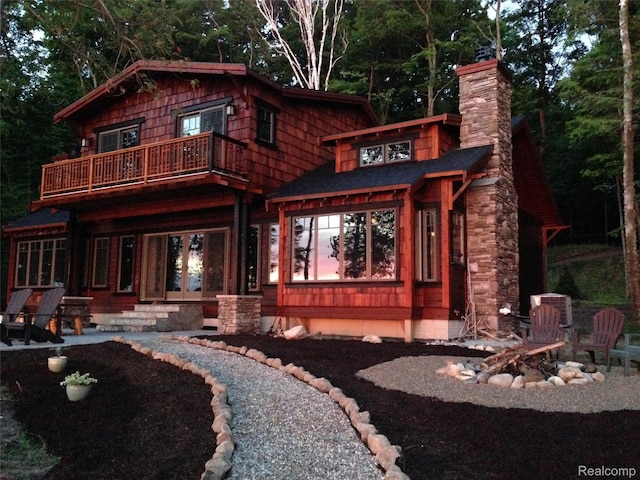 11720 Easy St, Kewadin, MI 49648 - rear view of house with a balcony, a chimney, and a patio area