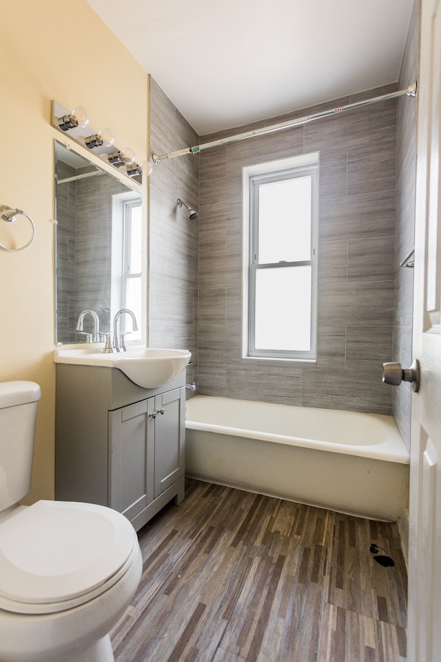 full bathroom with vanity, toilet, tiled shower / bath combo, and wood-type flooring