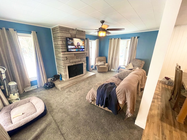 living room with carpet floors, ornamental molding, a fireplace, and ceiling fan