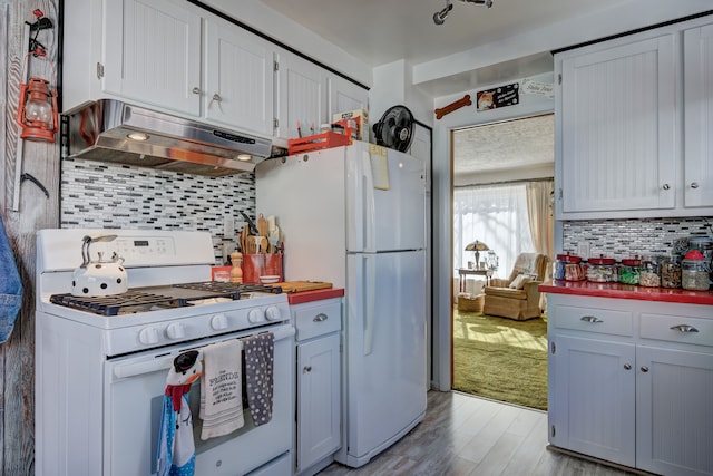 kitchen with light hardwood / wood-style flooring, white appliances, white cabinetry, and backsplash