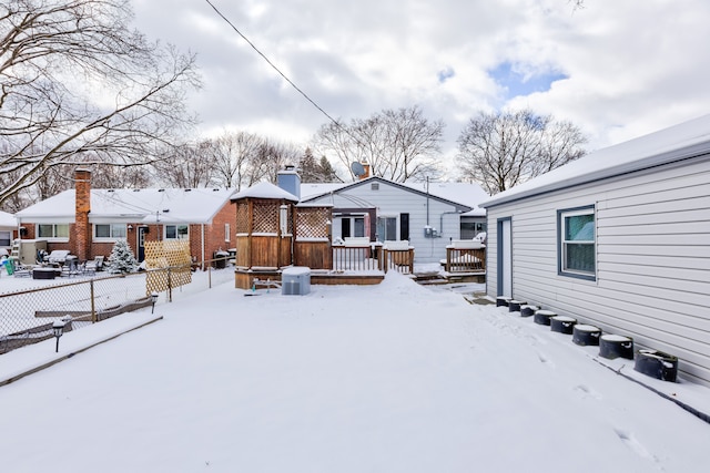 snow covered rear of property featuring a deck