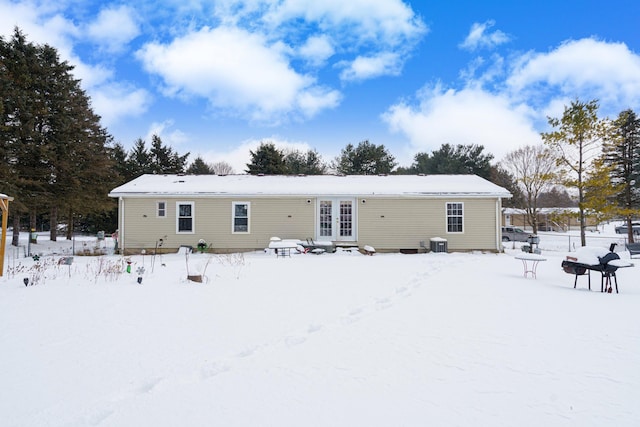 snow covered house featuring cooling unit