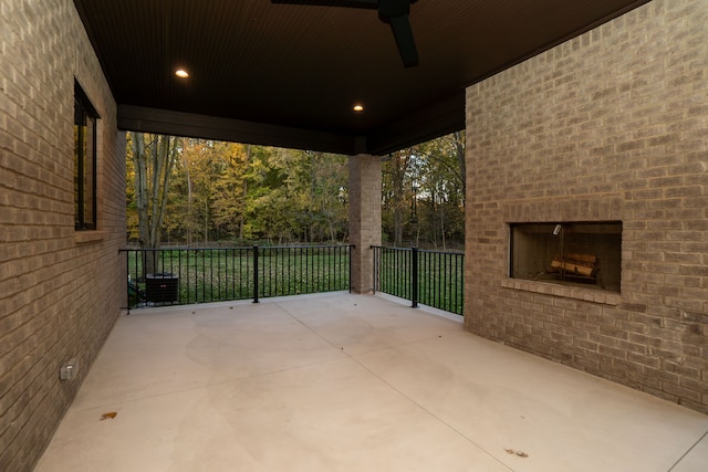 view of patio / terrace featuring an outdoor brick fireplace and ceiling fan