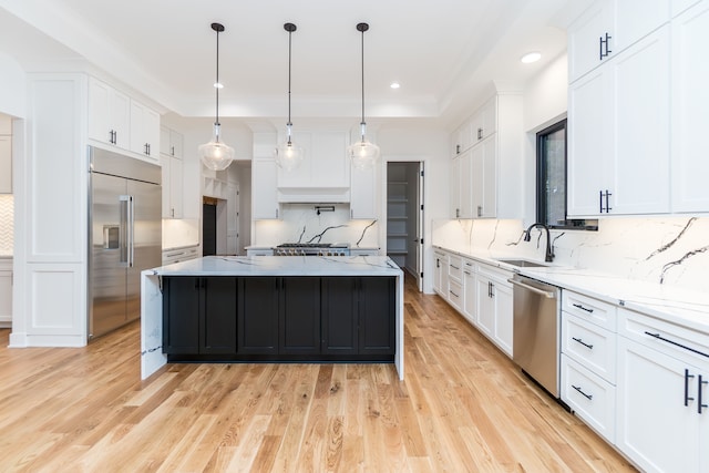 kitchen featuring stainless steel appliances, a center island, and white cabinets