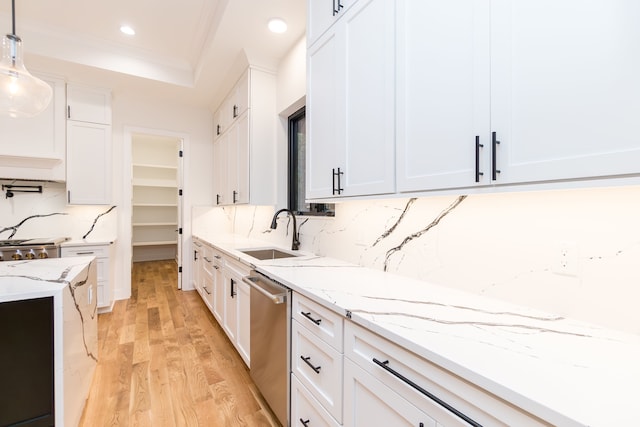 kitchen featuring sink, dishwasher, hanging light fixtures, white cabinets, and light wood-type flooring