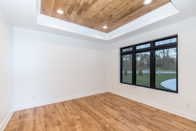 spare room with hardwood / wood-style flooring, a raised ceiling, and wooden ceiling