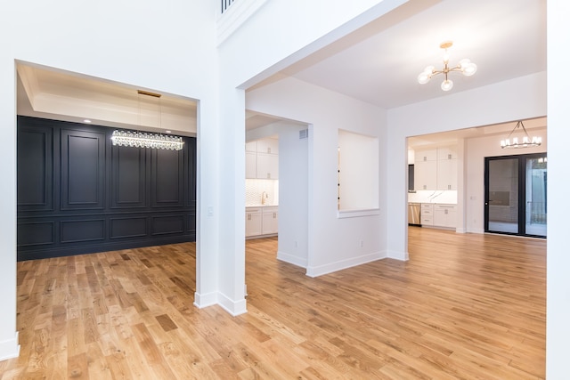 interior space featuring sink, a notable chandelier, and light hardwood / wood-style flooring