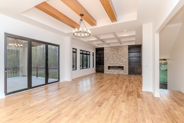 unfurnished living room with light hardwood / wood-style flooring, a fireplace, beamed ceiling, and a chandelier