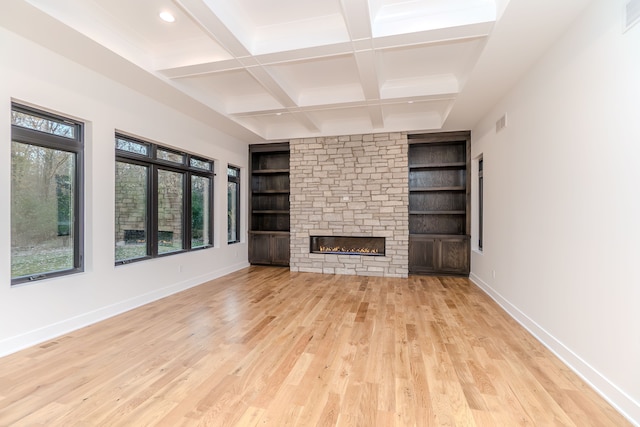 unfurnished living room featuring coffered ceiling, built in features, beam ceiling, and light hardwood / wood-style flooring