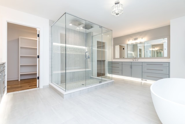 bathroom featuring vanity, shower with separate bathtub, and a chandelier