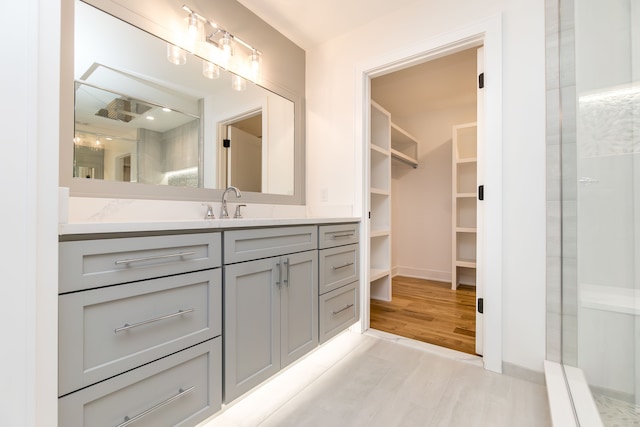 bathroom with vanity, wood-type flooring, and walk in shower