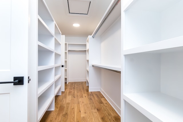 walk in closet with light hardwood / wood-style floors