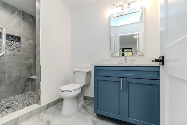 bathroom featuring tiled shower, vanity, and toilet