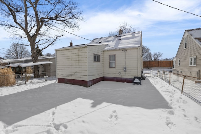 view of snow covered back of property