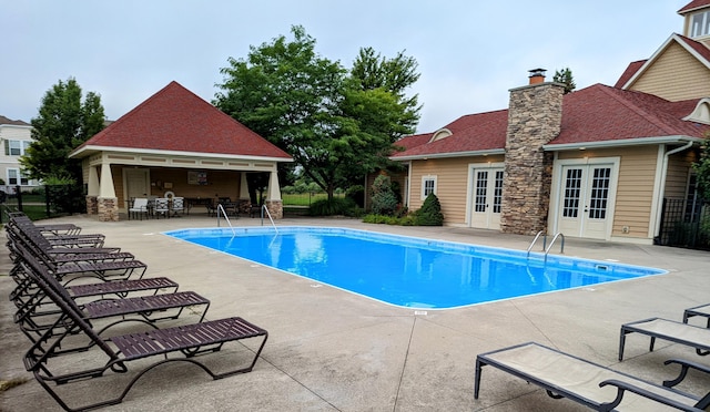 view of swimming pool featuring a patio and french doors