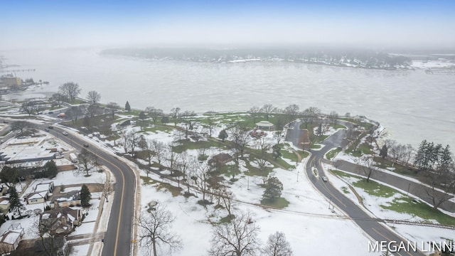 snowy aerial view with a water view