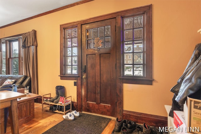 entrance foyer featuring wood-type flooring and ornamental molding