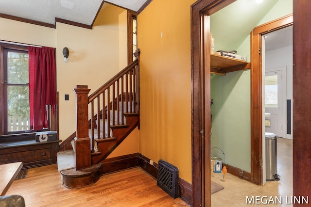 stairs with crown molding and hardwood / wood-style floors