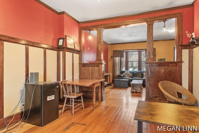 office area with decorative columns, crown molding, and light hardwood / wood-style flooring