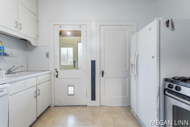 kitchen with white cabinetry, sink, and white appliances