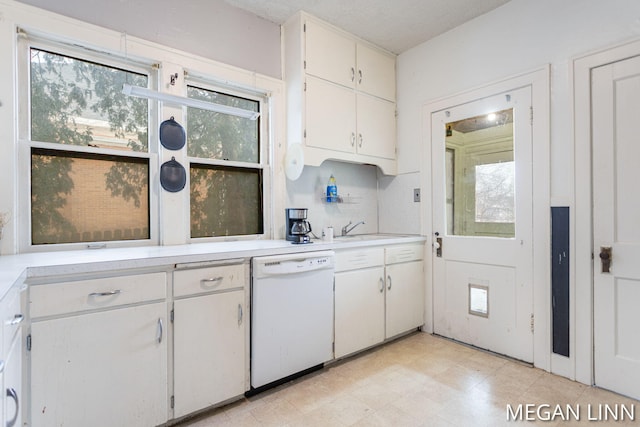 kitchen with plenty of natural light, dishwasher, sink, and white cabinets