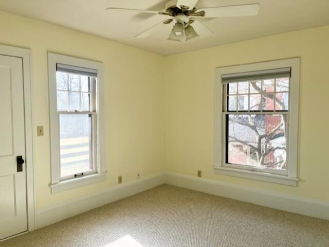 carpeted spare room with ceiling fan