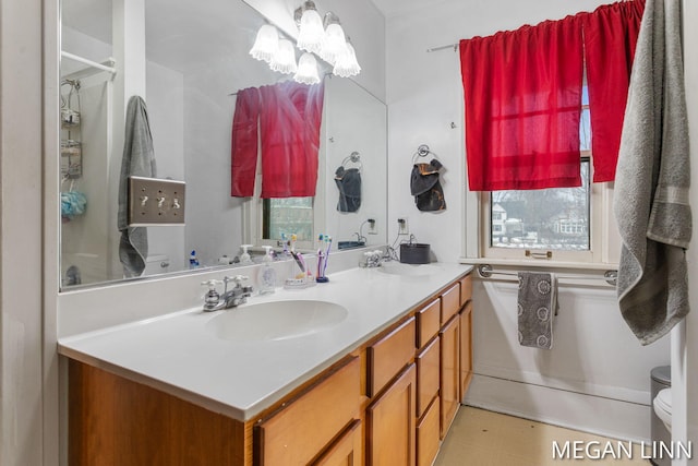 bathroom featuring vanity, toilet, and an inviting chandelier