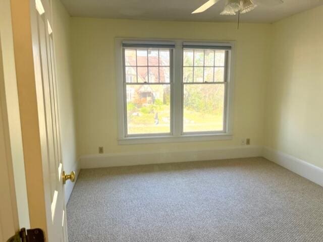 unfurnished room featuring light colored carpet and ceiling fan