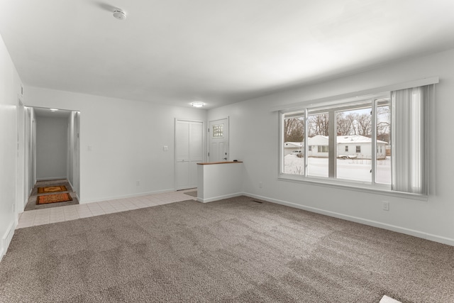 unfurnished room with light colored carpet and baseboards