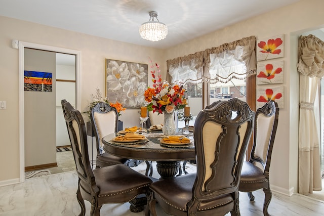 dining space with baseboards, a healthy amount of sunlight, and an inviting chandelier