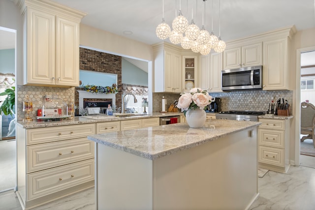 kitchen featuring marble finish floor, stainless steel appliances, a kitchen island, and decorative light fixtures