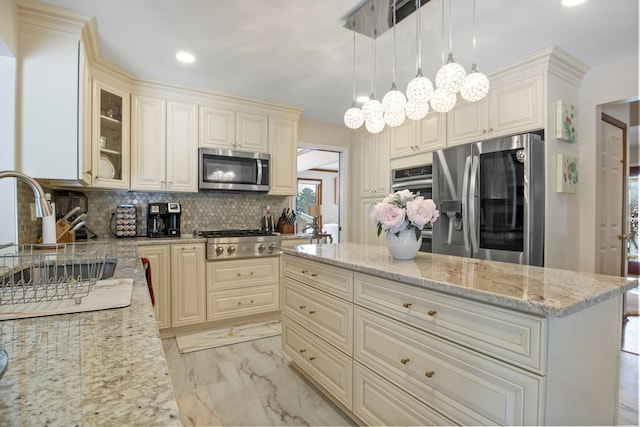 kitchen with a sink, marble finish floor, hanging light fixtures, appliances with stainless steel finishes, and glass insert cabinets