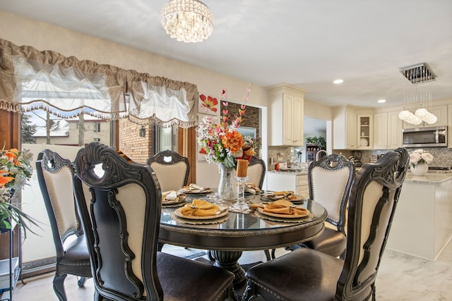 dining room featuring an inviting chandelier, visible vents, marble finish floor, and recessed lighting