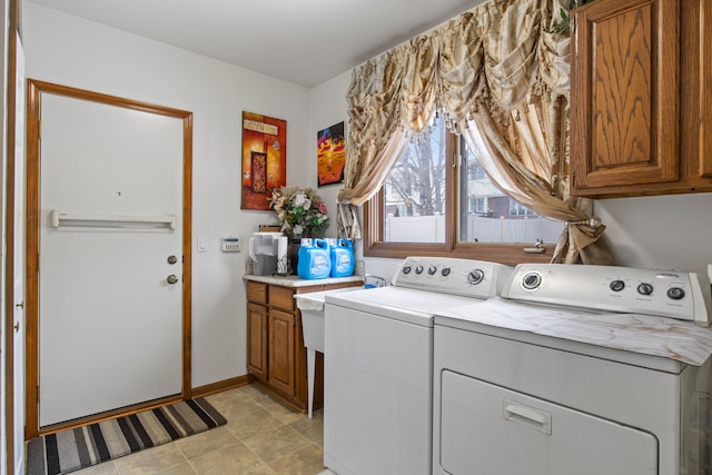 clothes washing area featuring cabinet space, baseboards, and separate washer and dryer