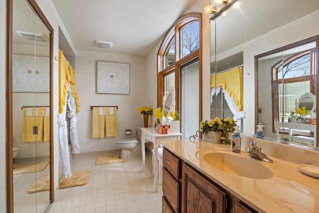 bathroom featuring tile patterned flooring, baseboards, vanity, and toilet