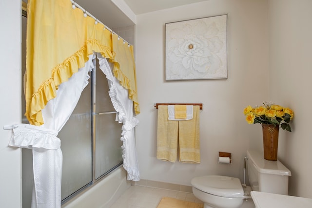 bathroom featuring toilet, tile patterned flooring, and bath / shower combo with glass door