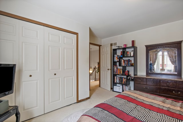 bedroom featuring visible vents, a closet, and light colored carpet