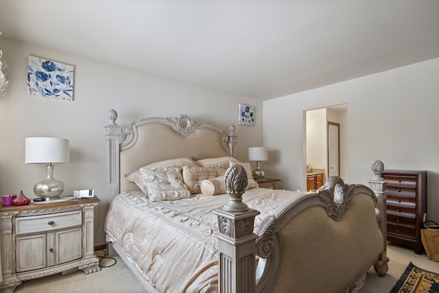 bedroom with light colored carpet and ensuite bathroom