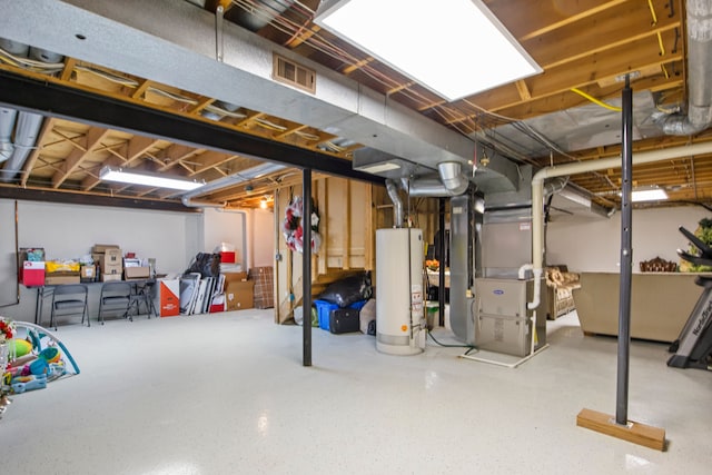 unfinished below grade area featuring gas water heater, visible vents, and heating unit