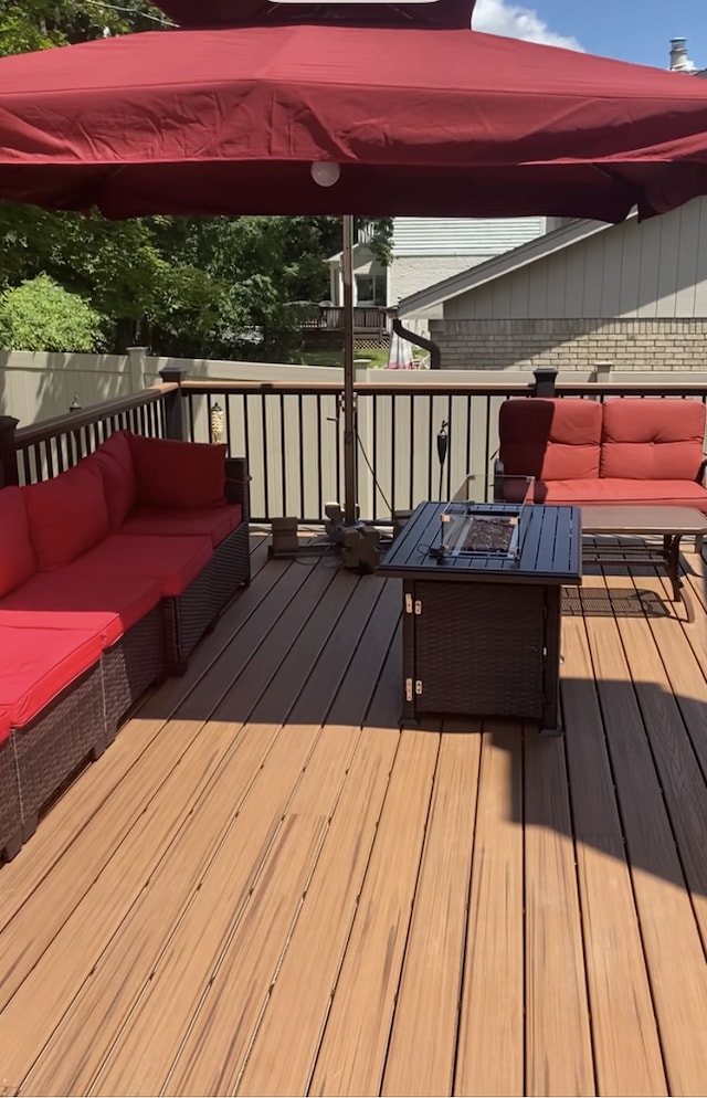 deck with an outdoor living space with a fire pit