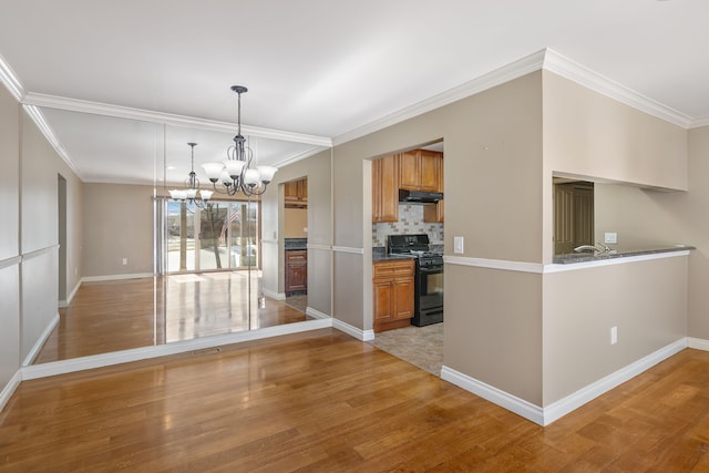 unfurnished dining area with light wood-style flooring, a chandelier, and baseboards