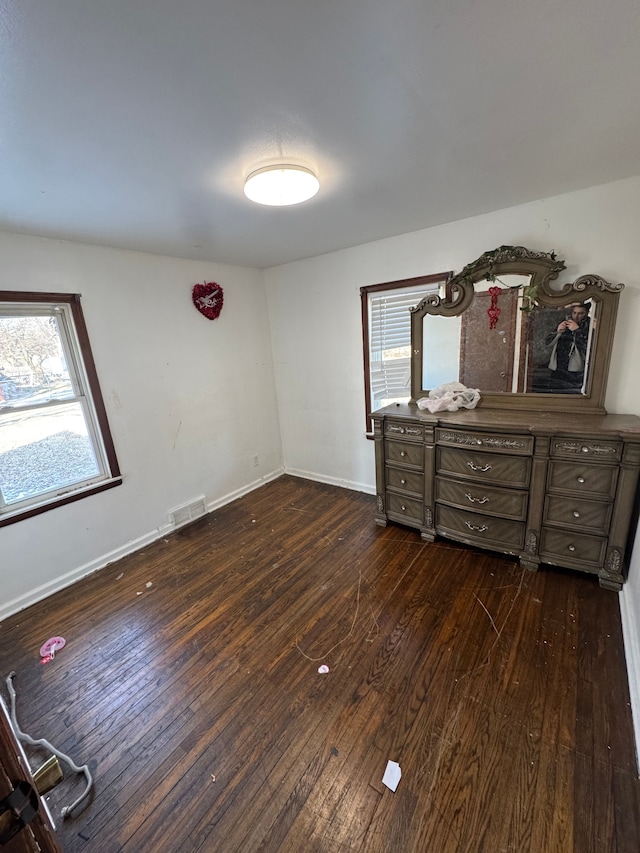 bedroom featuring dark hardwood / wood-style flooring and multiple windows