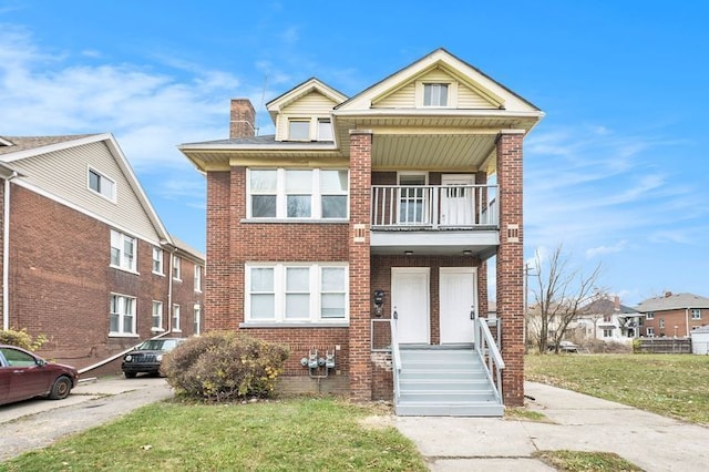 view of front of house featuring a front yard and a balcony